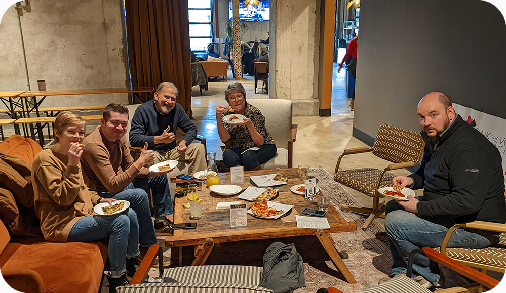 members of RTVKY sitting around a low table, eating and drinking